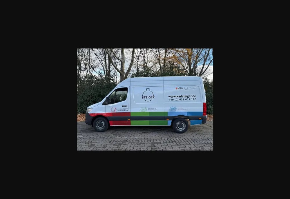Weißer Karl-Steiger-Transporter mit Fahrzeugbeschriftung von Louis Design